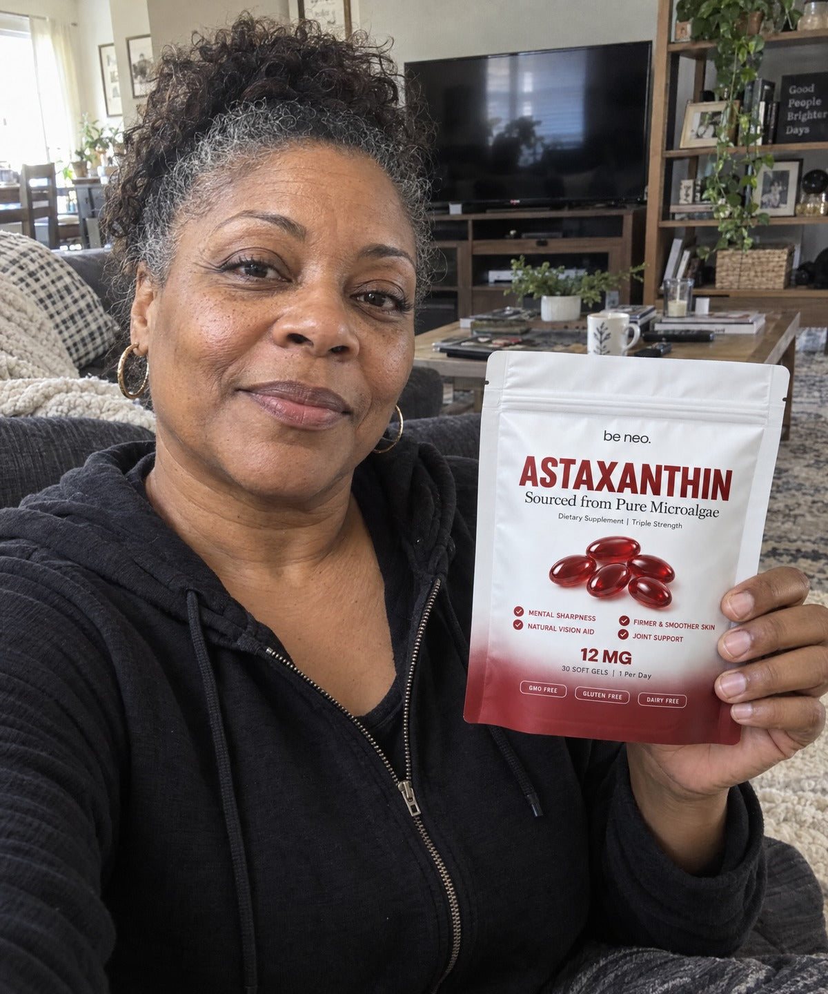 Woman on her couch holding Be Neo Astaxanthin