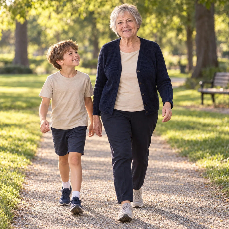 A woman in her seventies walking in the park with her grandson